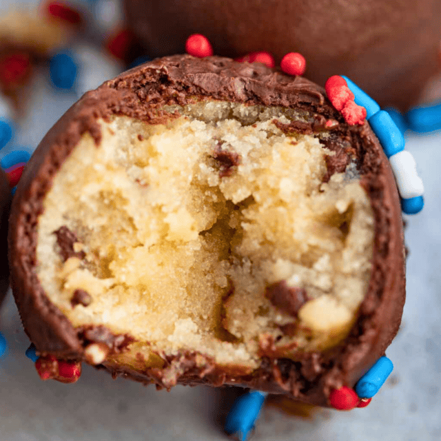 a bite taken out of edible no-bake dessert coated in chocolate with sprinkles