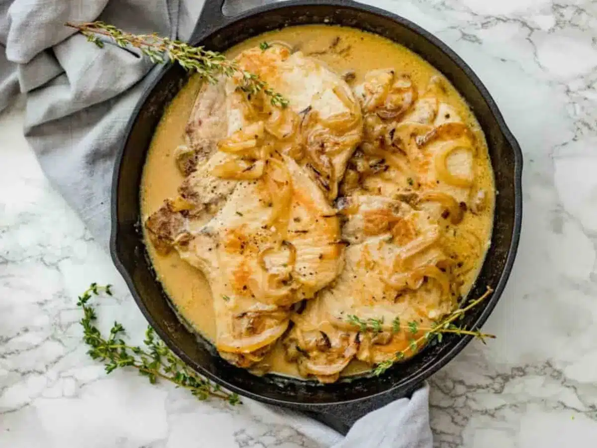 Top view of pork in pan smothered