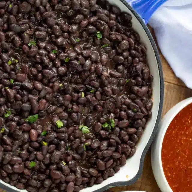 beans in a skillet with salsa on the side