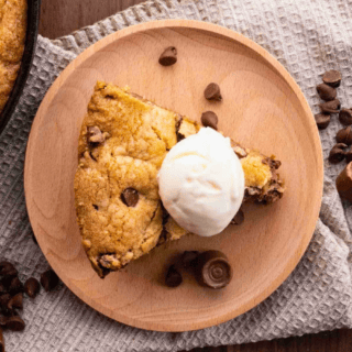 aerial view of a slice of cookie on a plate with ice cream on top with some chocolate