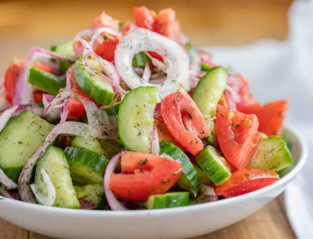 Cucumber Tomato side salad on a white plate