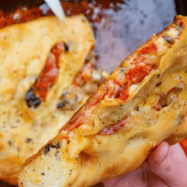 hand holding finished pizza