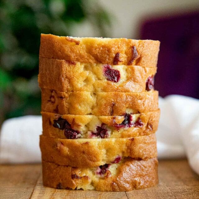 Stack of cranberry bread slices on wooden table