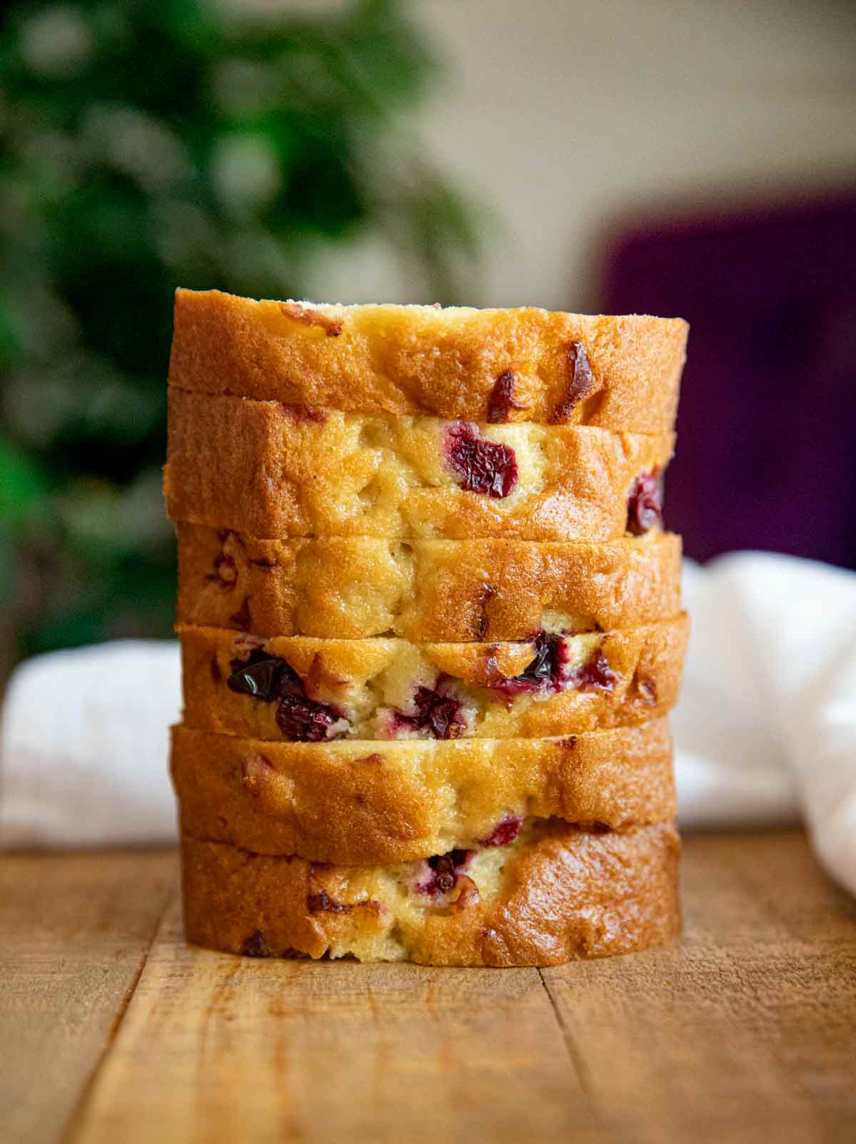 Stack of cranberry bread slices on wooden table