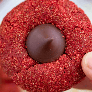 someone holding a bright colored dessert with chocolate in the middle