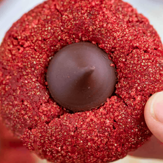 someone holding a bright colored dessert with chocolate in the middle