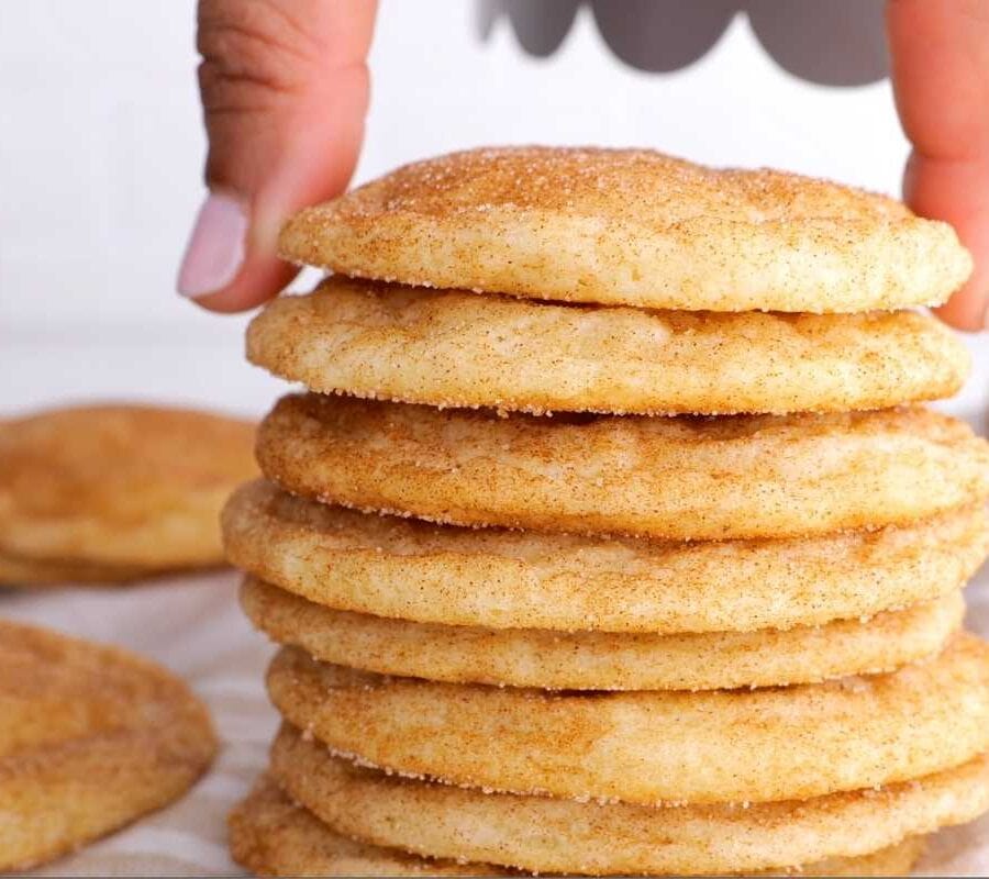 Snickerdoodle Cookies stacked with hand placing