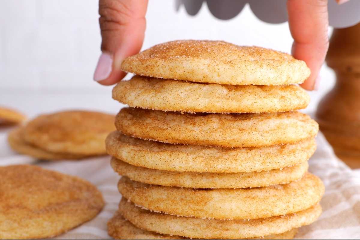 Snickerdoodle Cookies stacked with hand placing