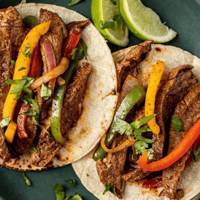 plated steak and veggies on tortillas