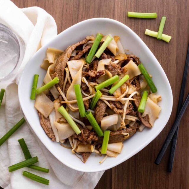 Beef Chow Fun in bowl with green onions