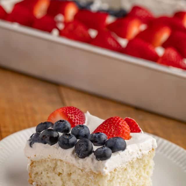 Slice of white cake with strawberries and blueberries