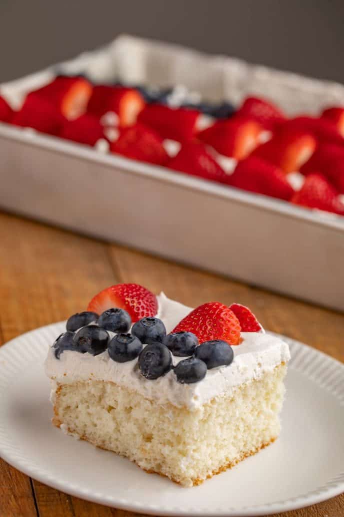 Slice of white cake with strawberries and blueberries