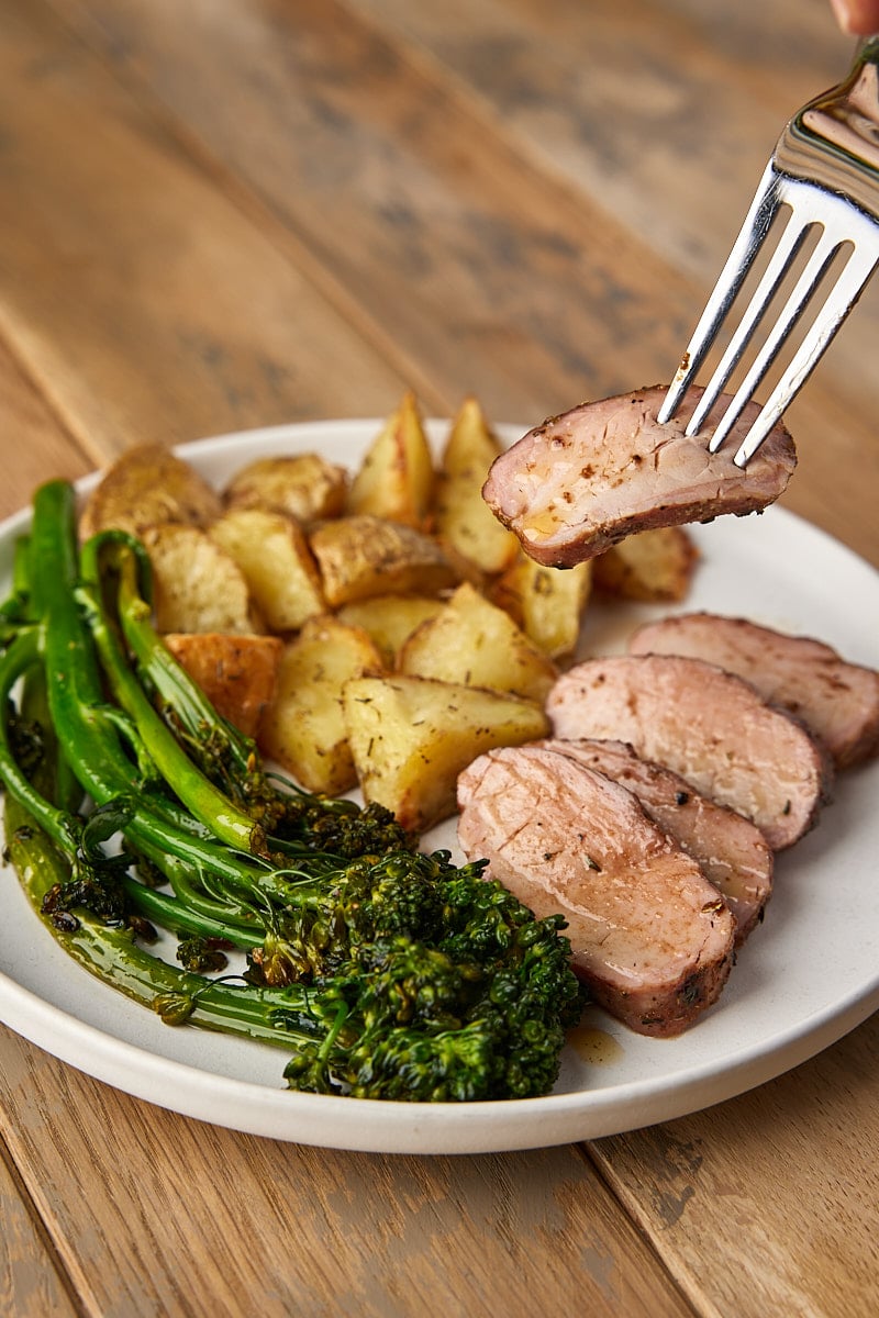 Grilled Pork Tenderloin sliced on plate with potatoes and broccoli
