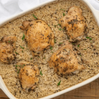Chicken on top of rice in baking dish