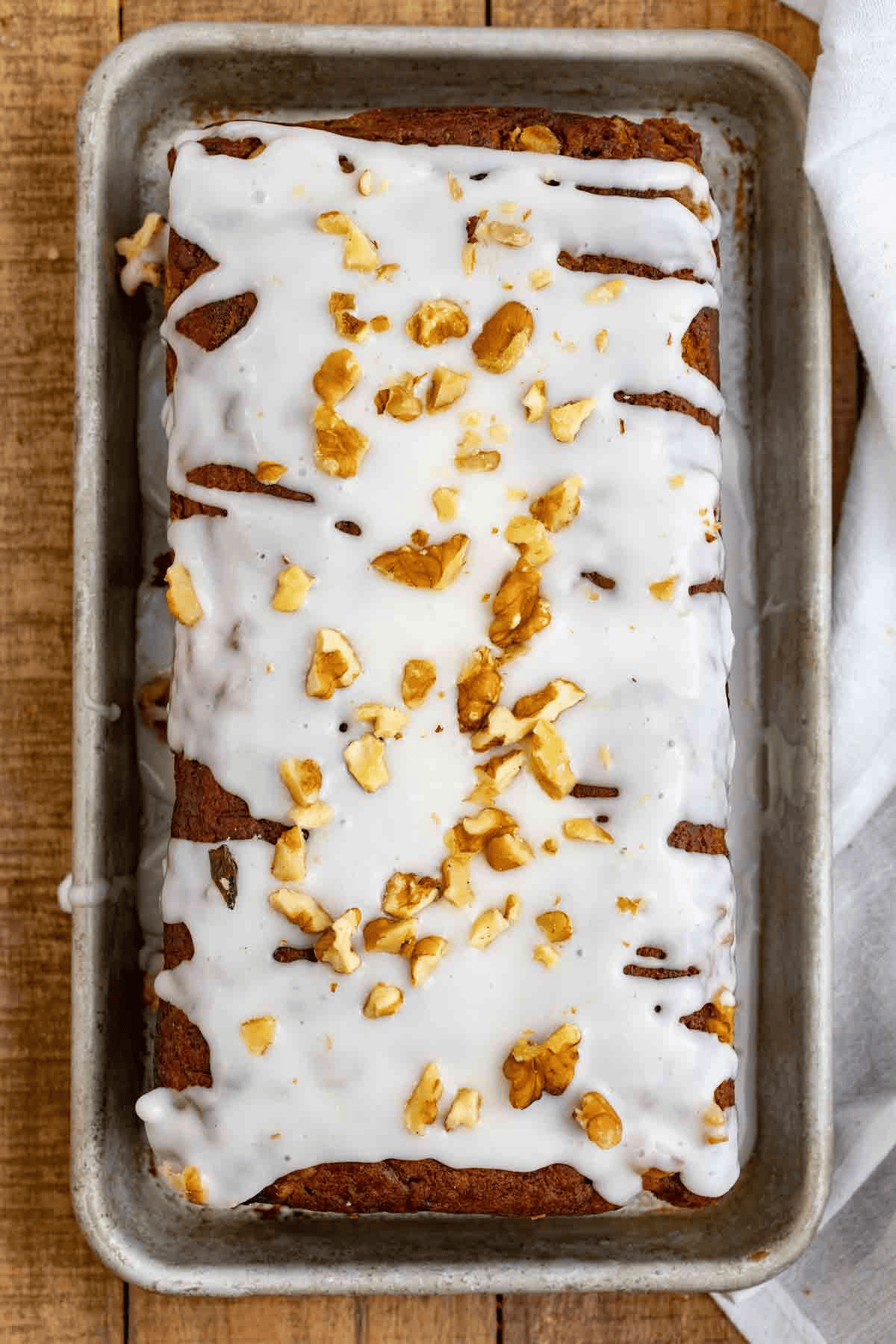Sweet bread loaf with glaze and nut topping shown from above