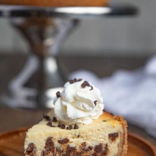 Slice of Chocolate Chip Cheesecake with Whipped Cream on plate