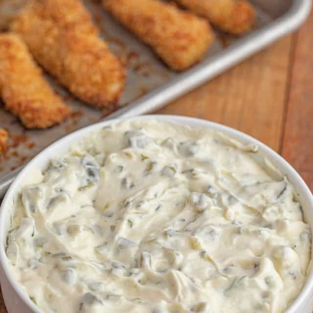 Tartar Sauce in white bowl with fish sticks in background