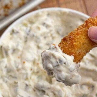fish piece being dipped in sauce