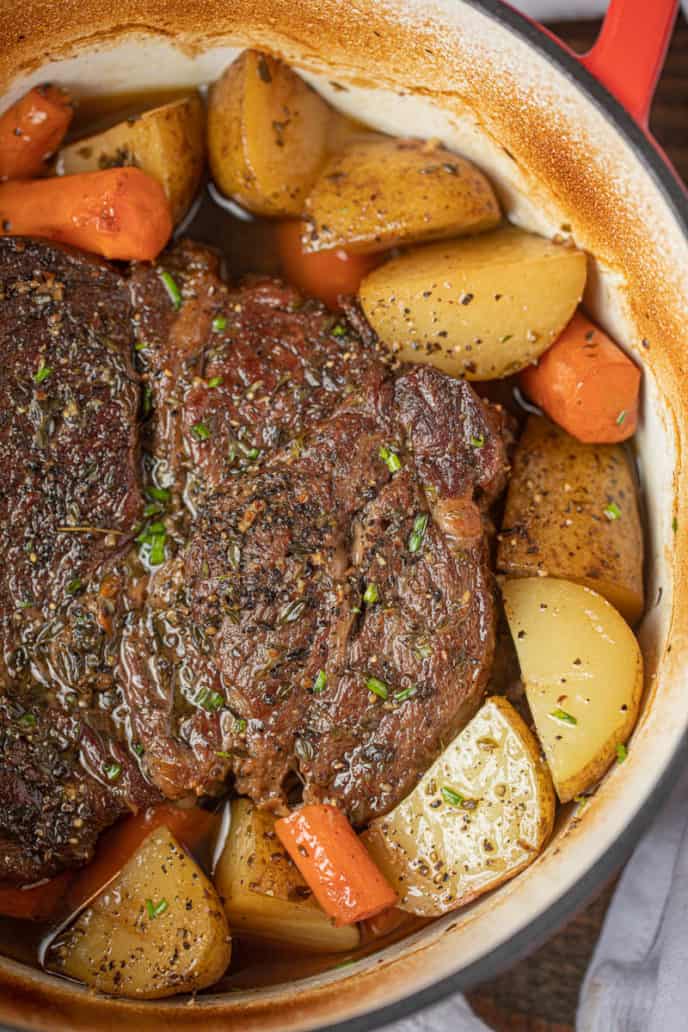 Classic Pot Roast with potatoes and carrots in dutch oven.