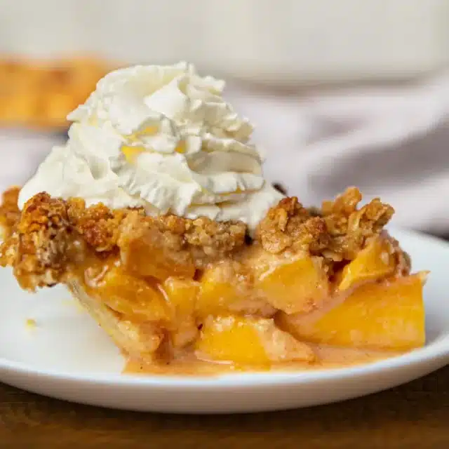 slice of pie on a plate with whip cream on top