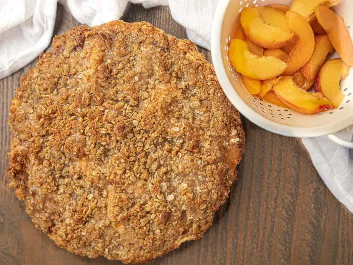 above view of whole pie and bowl of peaches 