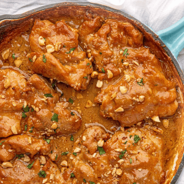 chicken in a skillet with peanut sauce