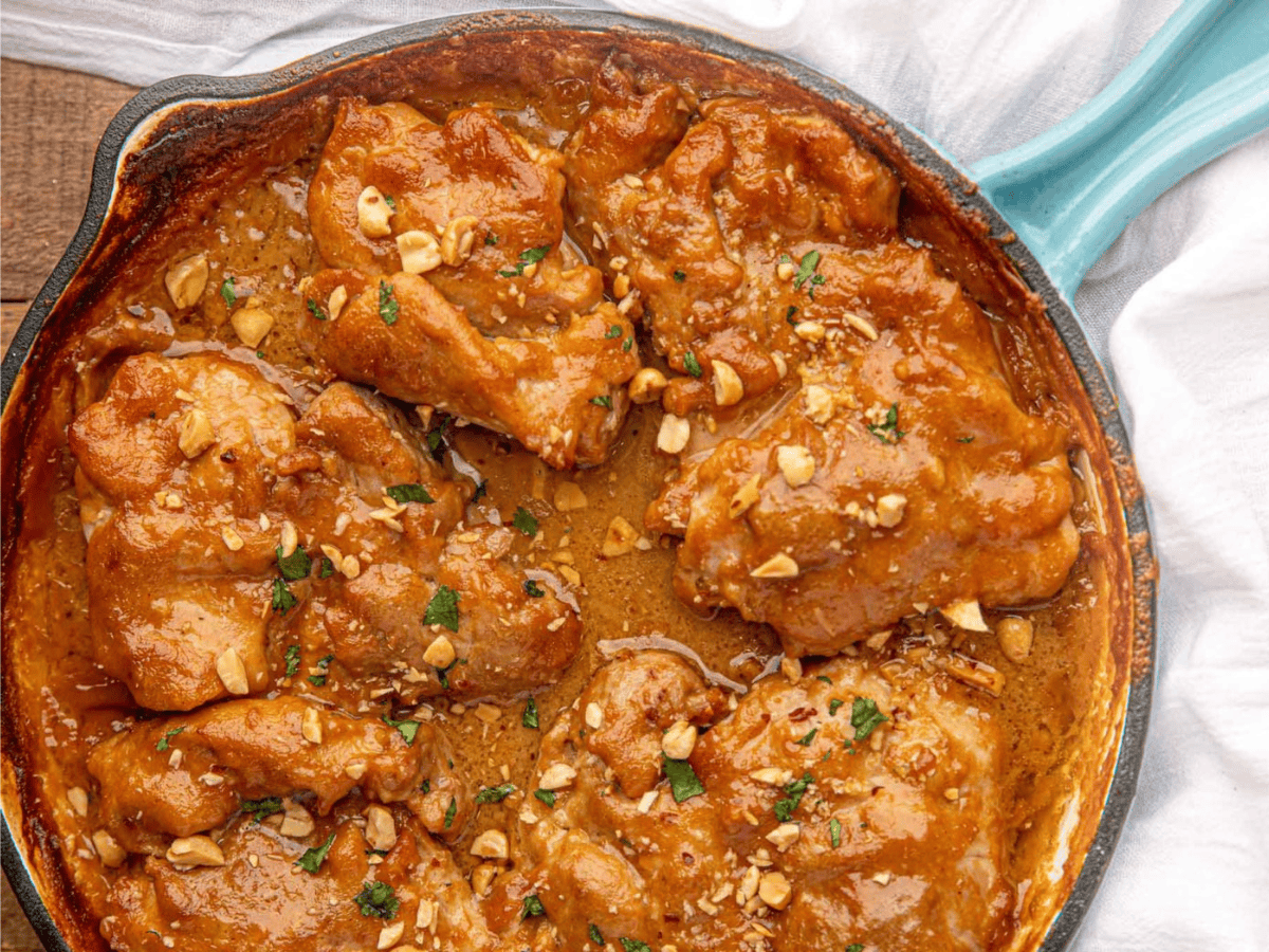 chicken in a skillet with peanut sauce 