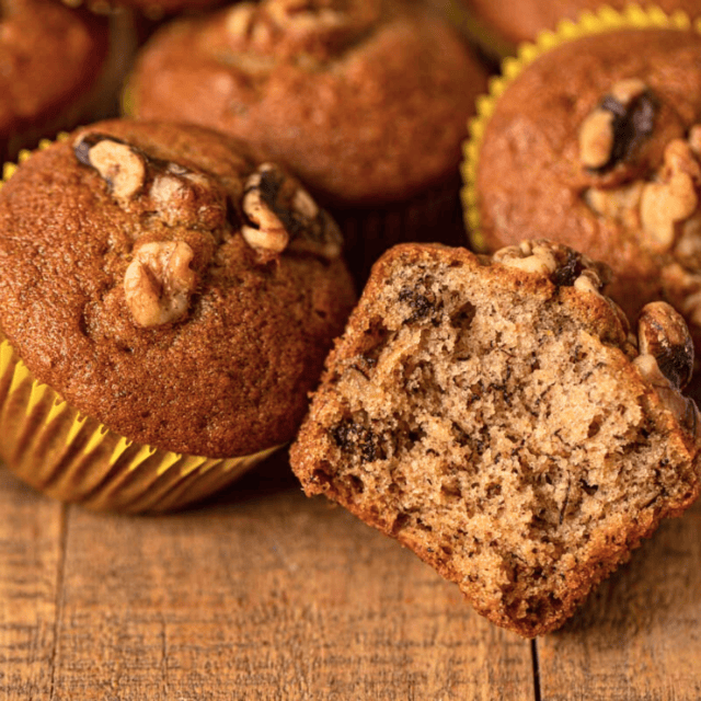 Baked muffins, one in front with bite taken out