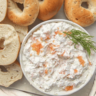 Closeup of spread in a bowl with garnishment and bagels