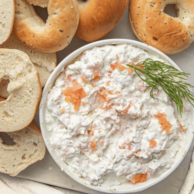 Closeup of spread in a bowl with garnishment and bagels