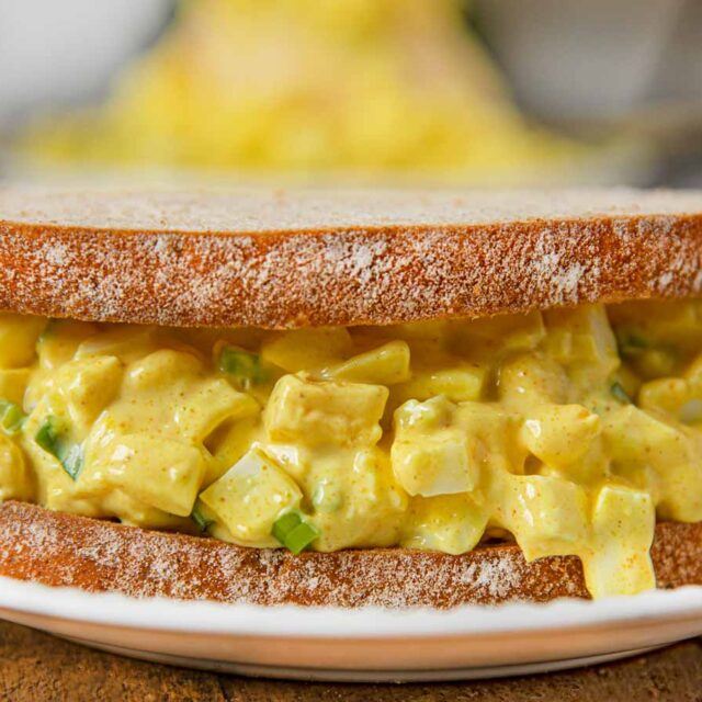 sandwich on white plate stuffed with egg salad