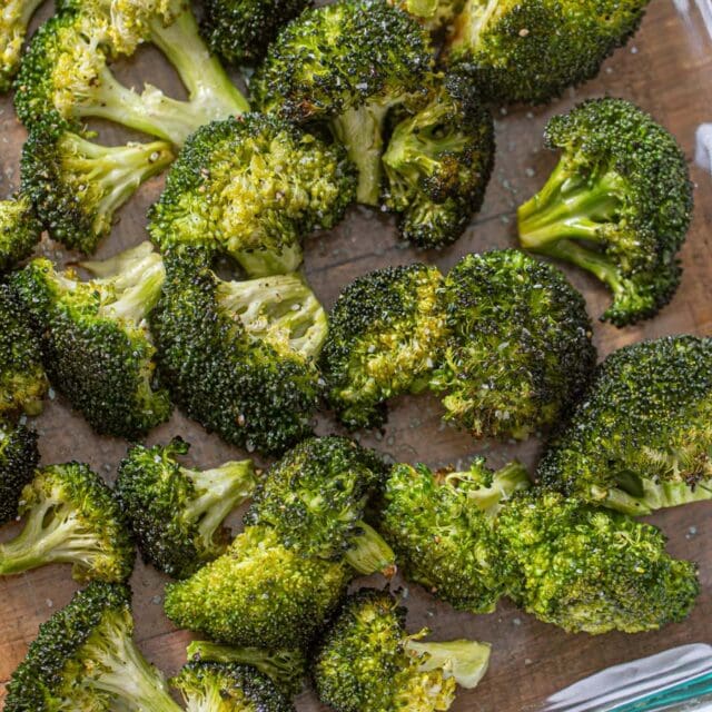 Cooked broccoli florets spread out in baking dish.