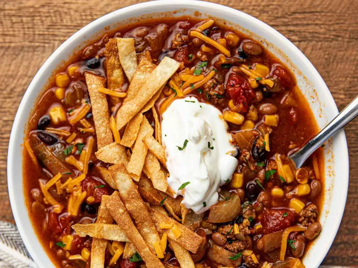 bowl of soup with tortilla strips and sour cream 