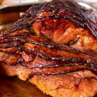 Front view of baked ham in pan with slices falling slightly