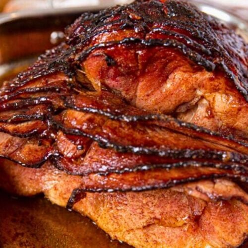 Front view of baked ham in pan with slices falling slightly