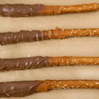 dipped pretzels lined up on parchment paper