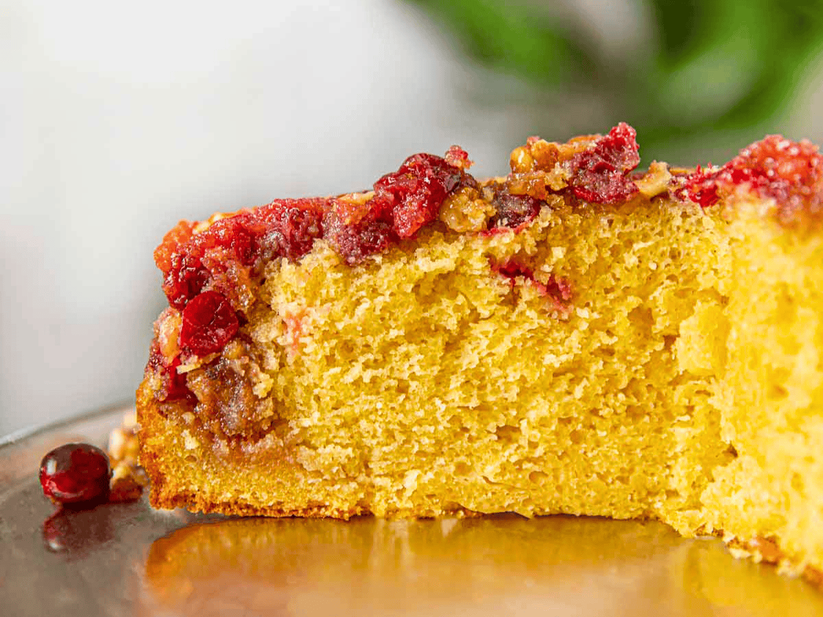 tart berry with nuts inside of cake on silver platter with slice cut out