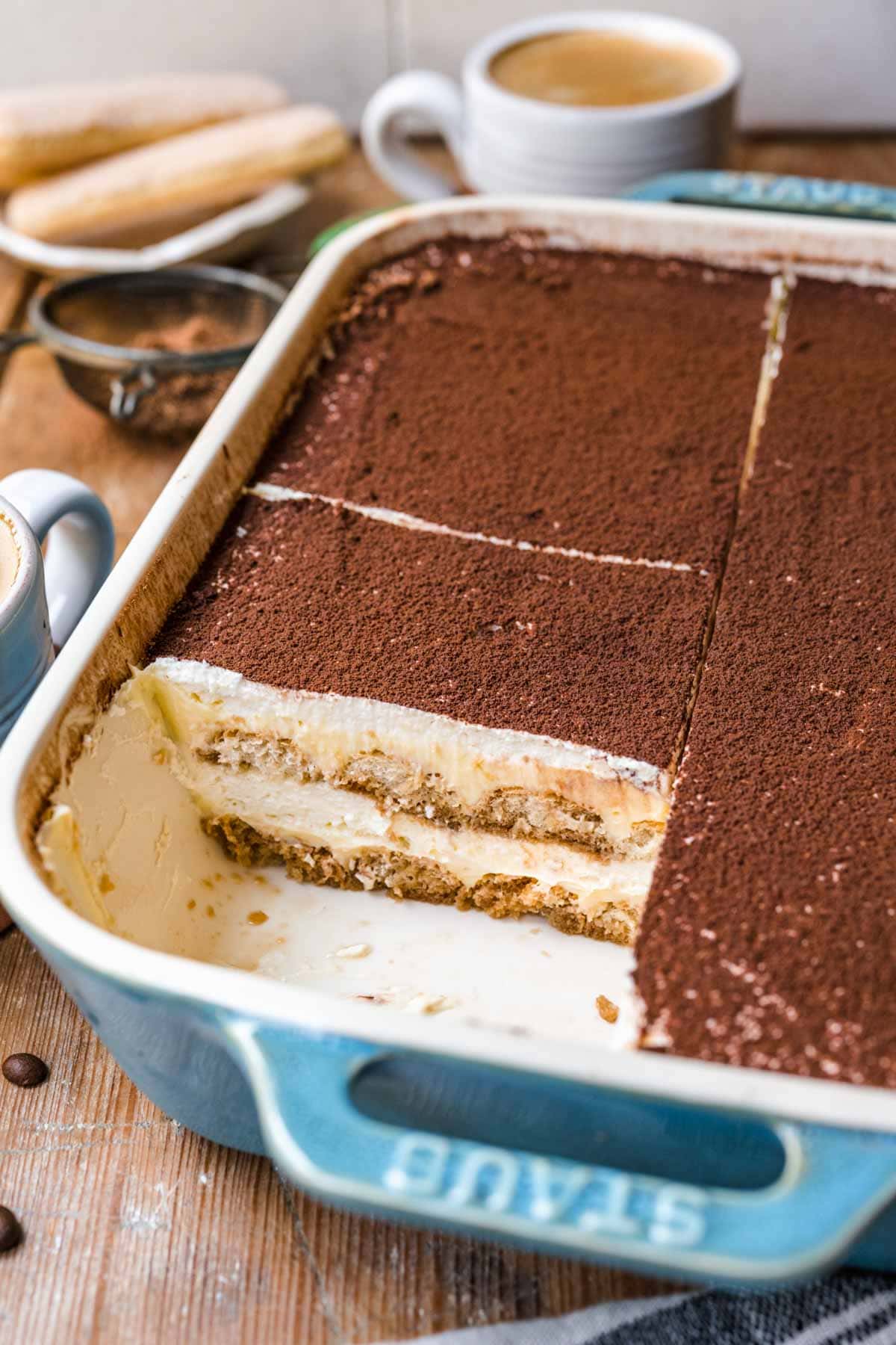 Tiramisu sliced in a blue baking pan.