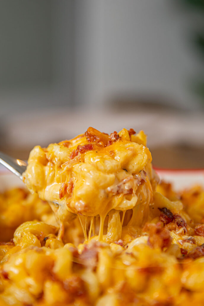 Cheesy Scoop of Bacon Mac and Cheese coming out of a baking dish