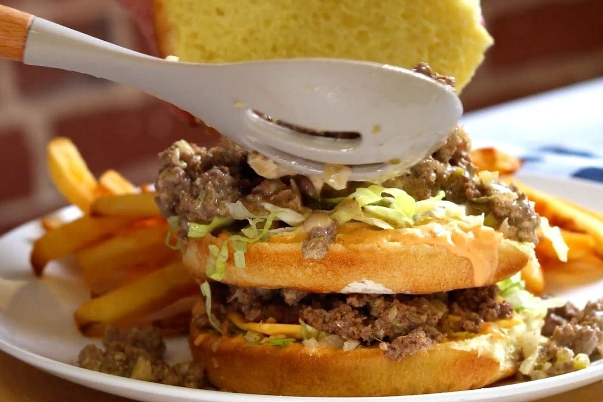 spooning meat onto sandwich 