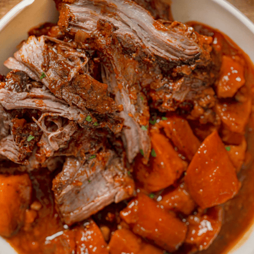 Sweet Potatoes and Carrots in a white bowl with gravy