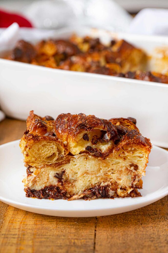 Een stukje roomkaas croissant ovenschotel met chocoladechips op wit bord