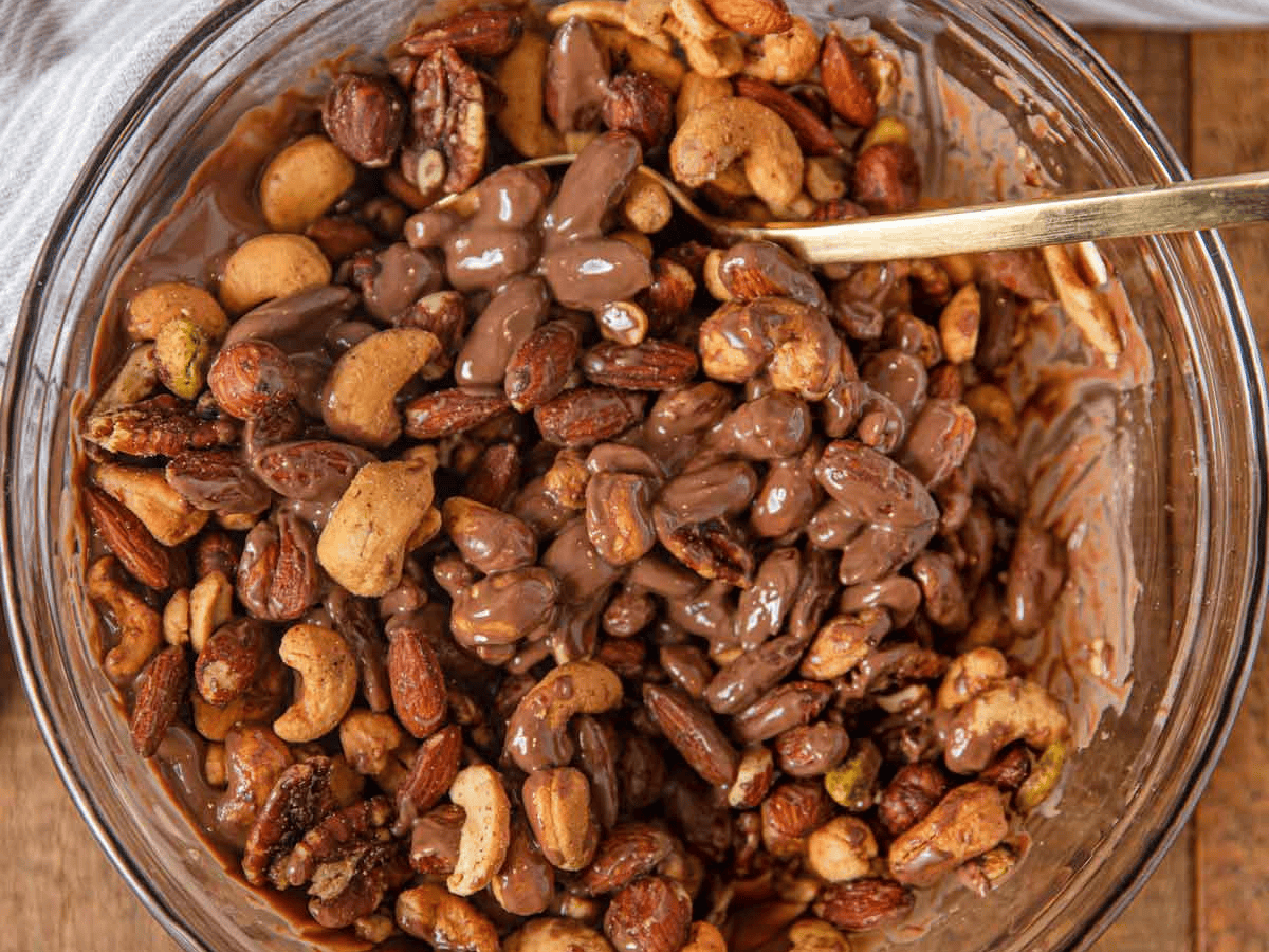 Chocolate and nuts in a mixing bowl with spoon