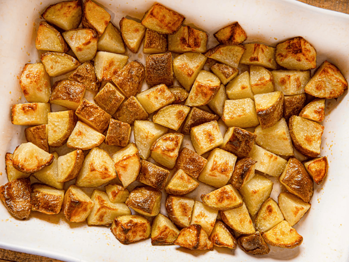 top view of cut potatoes in baking pan with seasoning