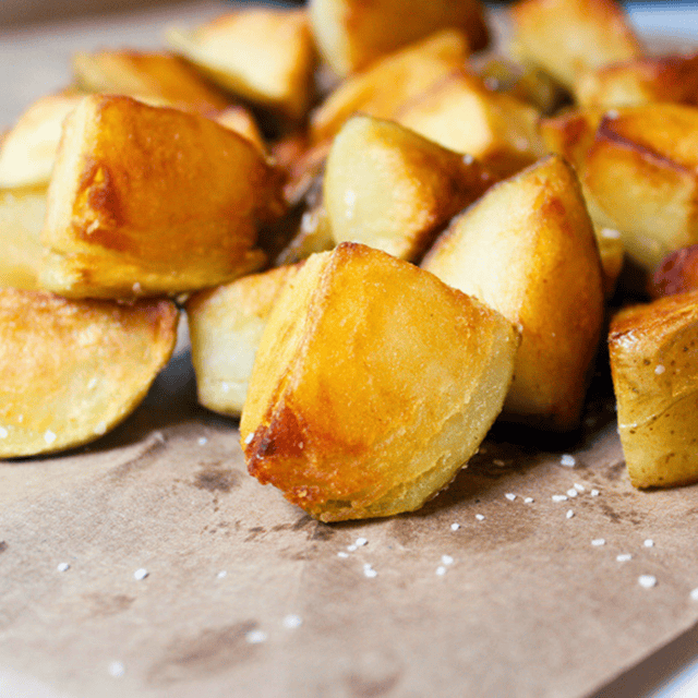 close up of cut potatoes with salt on baking sheet
