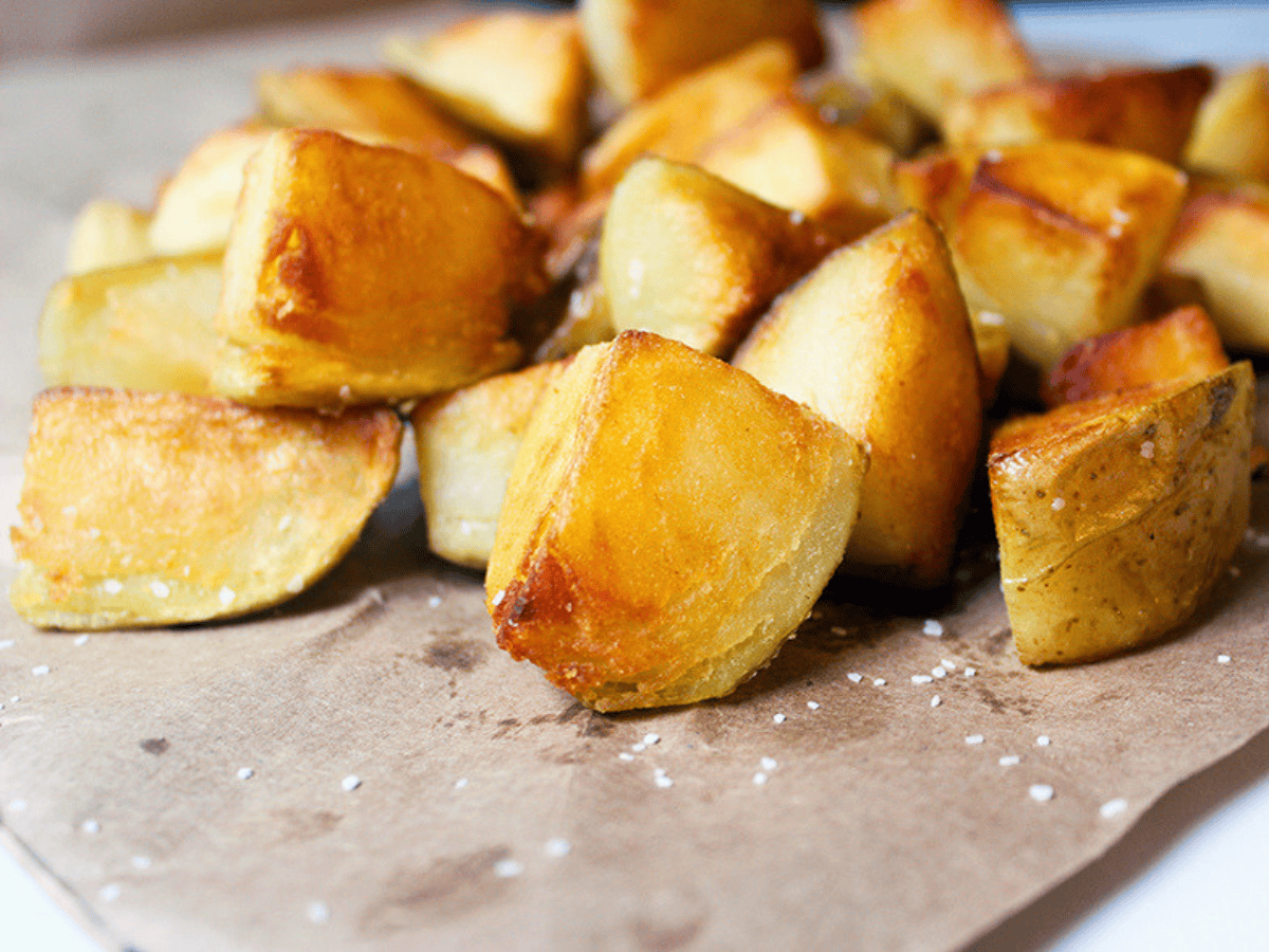 close up of cut potatoes with salt on baking sheet