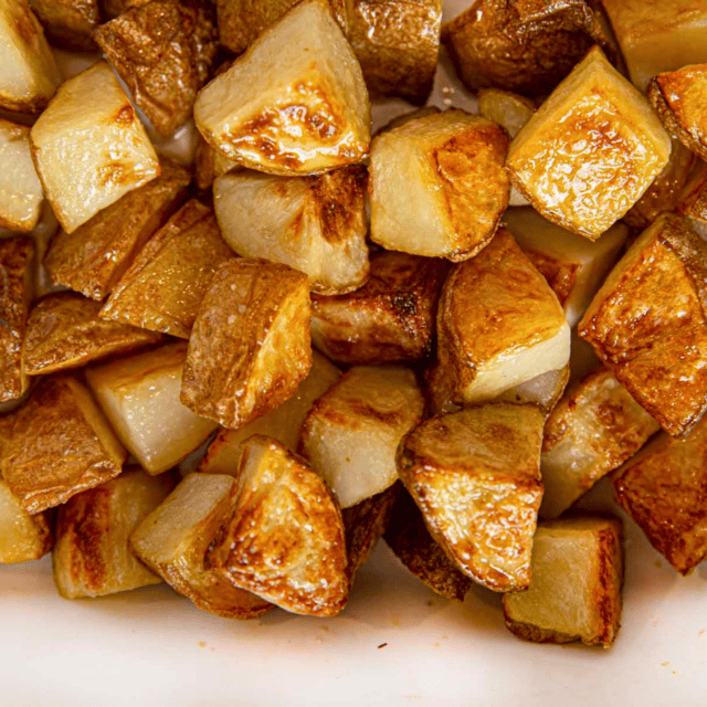 cut potatoes in baking pan with salt