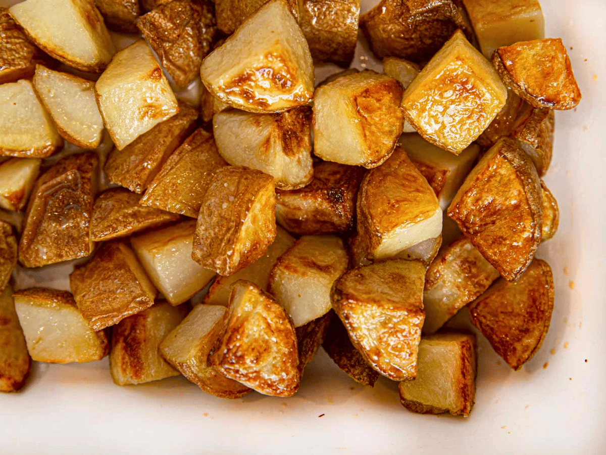 cut potatoes in baking pan with salt