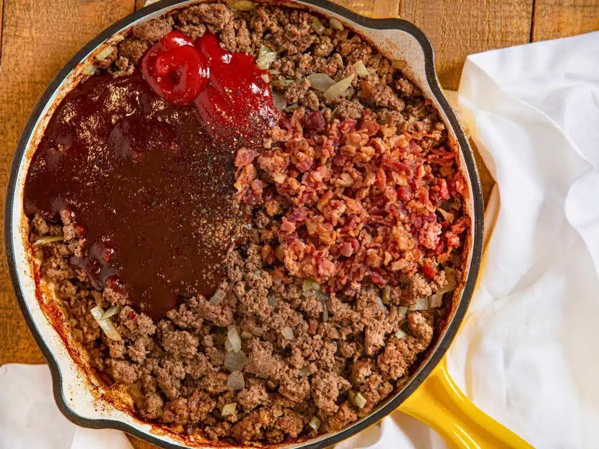ground beef, sauces, onions, and bacon in a cooking skillet