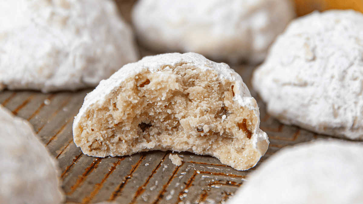 Almond cookie with bite taken out on a baking sheet